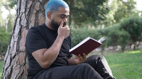 Black man reading personal diary and book in park for relaxation Stock Footage 287487769