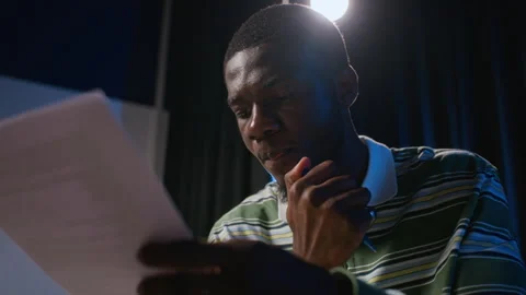 Black Man Reading Script on Stage during Student Theater Rehearsal Stock Footage 344532449
