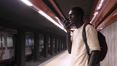 Black man recording audio message on mobile phone at the subway station Stock Footage 219800917
