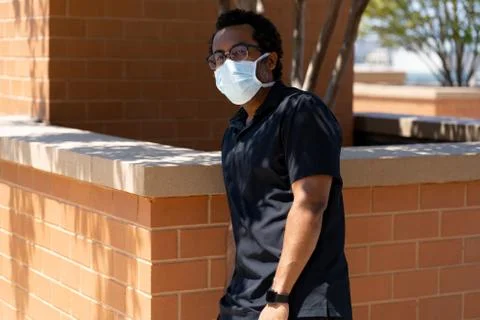 Black man relaxes while wearing protective face mask social distancing Stock Photos