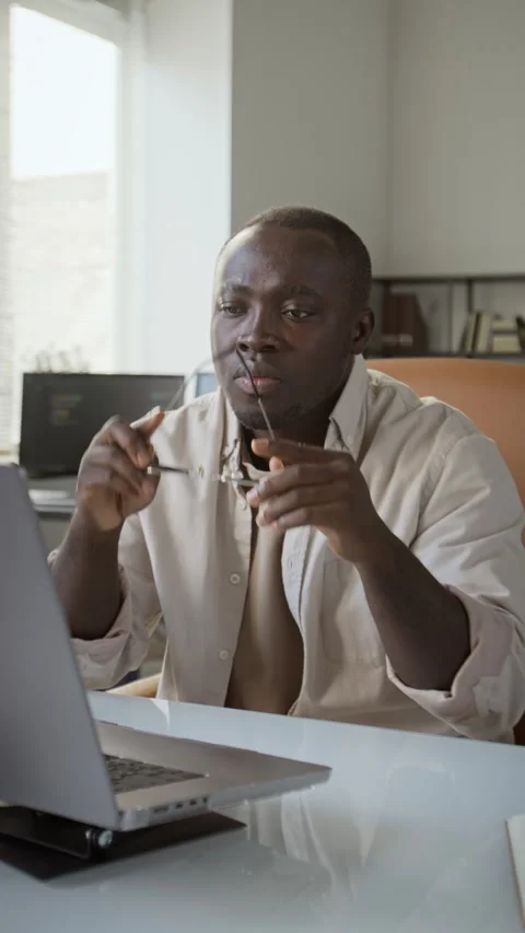 Black Man Removing Glasses While Working on Laptop in Office Stock Footage 348140310