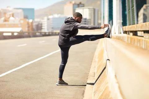 Black man, runner and stretching legs in city for fitness, wellness and war.. Stock Photos