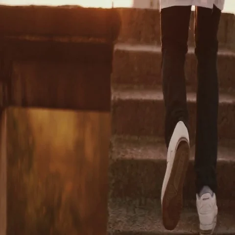 Black man running through the stairs on the roof towards sunset,sunrise,full HD Video stock 69642663