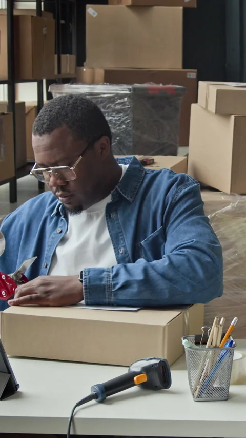Black Man Scanning Barcode on Parcel Inside E-commerce Warehouse 動画素材 337305355