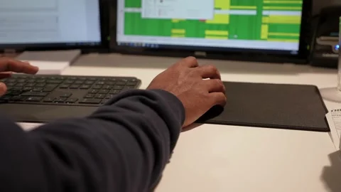 Black man scrolling a mouse and typing on a keyboard at the office Stock Footage 235775485
