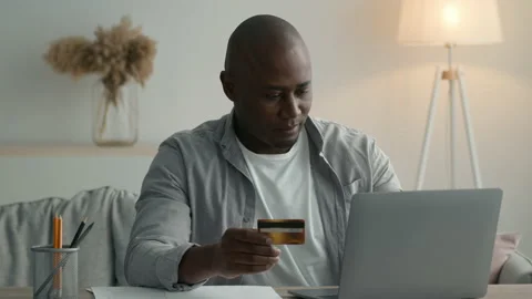 Black Man Shopping Using Laptop And Credit Card At Home Stock Footage 153209664