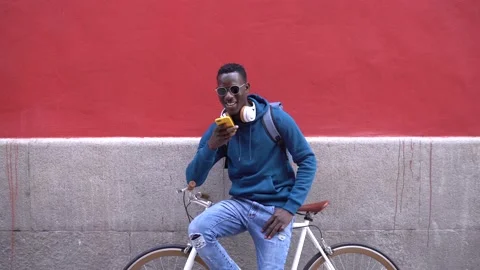 Black Man Sitting on Bike While Talking by Phone Outdoors. Stock Footage 141882070