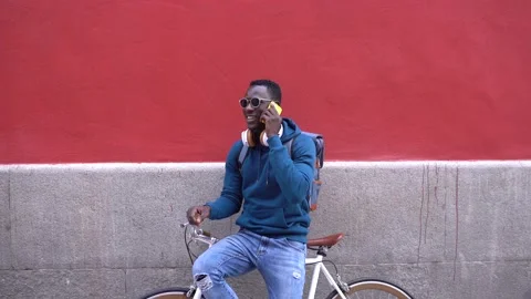 Black Man Sitting on Bike While Talking by Phone Outdoors. Stock Footage 141882087