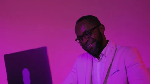 Black Man Sitting at Desk Working on Laptop Computer. African American Man in Stock Footage 231443200