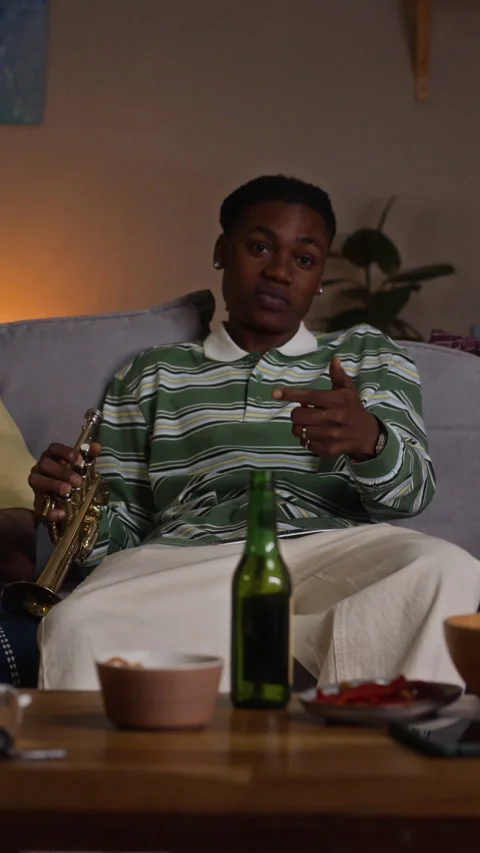 Black Man Sitting on Sofa Pointing Remote Control at Tv Screen Stock Footage 344643160