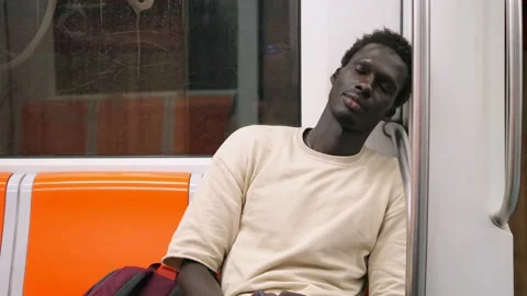 Black man sleeping in a underground Metro subway train Stock Footage 219787458
