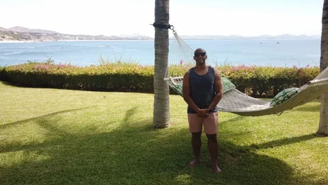 Black man smiling in front of hammock Stock Footage 113932085