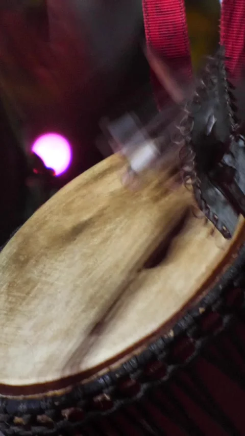 Black man standing with plaster on finger playing djembe with drum rings Video stock 230691086