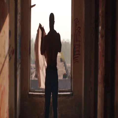 Black man standing in ruins in sunset,sunrise light in front of an open door Stock Footage
