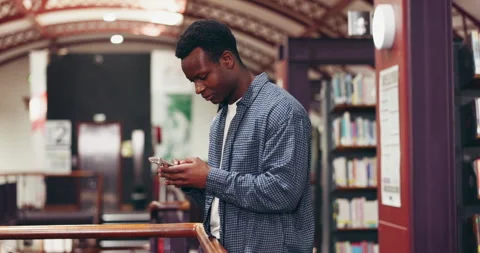 Black man, student and phone for texting in library, scroll and check Stock Footage 318278225