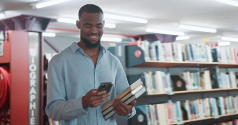 Black man, student and phone with texting at library for research project, books Stock Footage 319762089