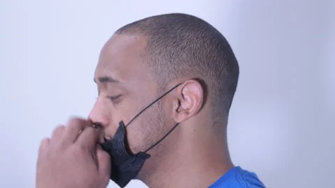 Black man Taking down face mask for a quick breather Stock Footage 135859047