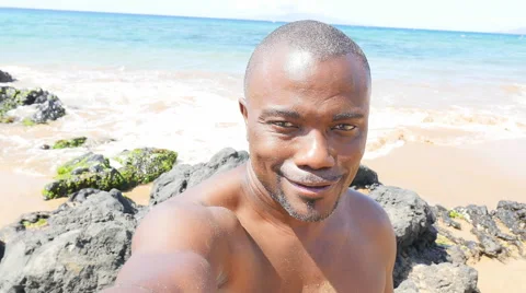 Black man taking a selfie on a beach Stock Footage 53013029