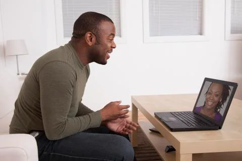 Black man talking to wife on computer Stock Photos