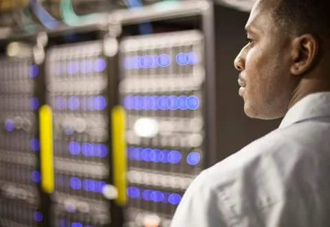 Black man technician doing diagnostic tests on computer servers in server farm. Stock Photos