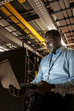 Black man technician doing diagnostic tests  on computer servers in server farm. Stock Photos