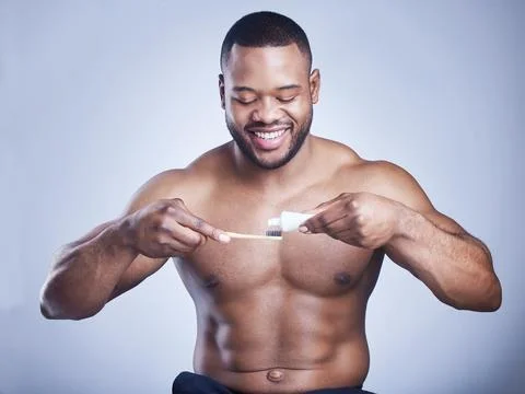 Black man, toothpaste and brushing teeth in studio, cosmetics and oral health on Stock Photos