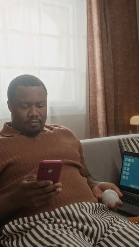 Black Man Tossing Baseball and Using Smartphone during Remote Work Break Stock Footage 337720347