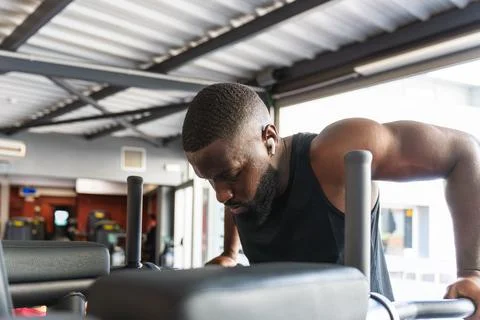 Black man training triceps on dips machine Foto stock