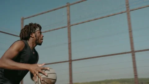 Black man trains doing slam dunk alone on a street basketball court Vídeo Stock 166834140