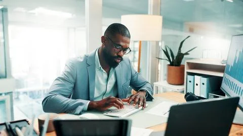 Black man, typing and computer with charts at office for review, report and.. Foto stock