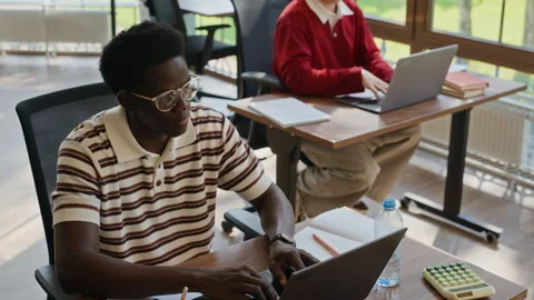 Black Man Typing on Laptop Computer in Modern Shared Office Stock Footage 343710729