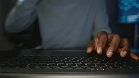 Black Man Typing on Laptop Keyboard in Dark Cybersecurity Office Stock Footage 346814555