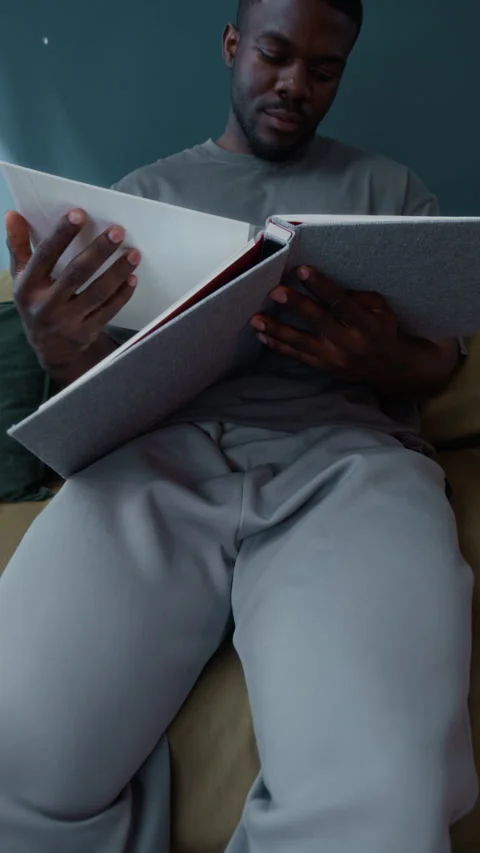 Black Man Under House Arrest Looking Through Photo Album Alone Stock Footage 313933292