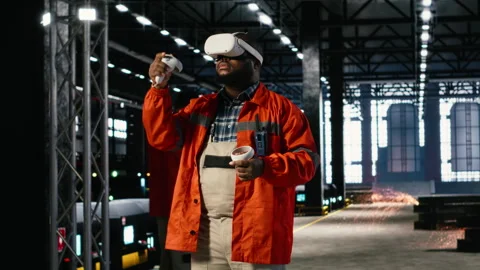 Black man uses VR glasses to examine 3D models of machinery in workshop Stock Footage 322207639