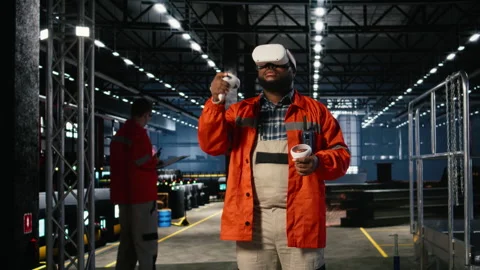 Black man uses VR glasses to examine 3D models of machinery in workshop Stock Footage 322207917