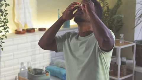 Black Man Using Eye Drops in Bathroom Stock Footage 226343721