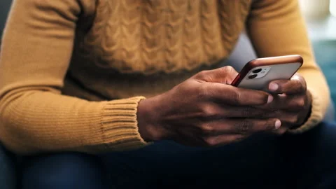 A black man is using his smartphone in an office Stock Footage 235218945