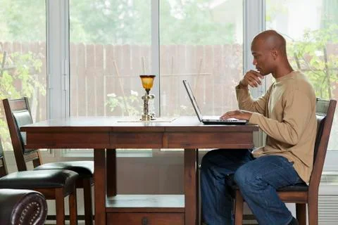 Black man using laptop at table Foto stock