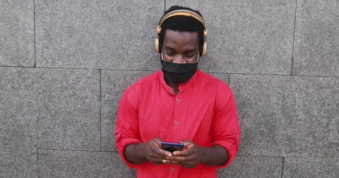 Black man using mobile phone wearing face protective mask Stock Footage 141050817