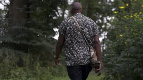 Black man walking down a path Stock Footage 235010068