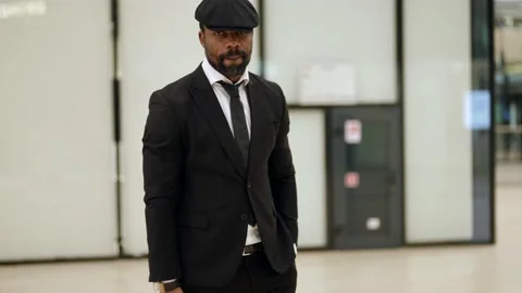 Black man is walking in mall or office center, portrait of serious Видео 169411999