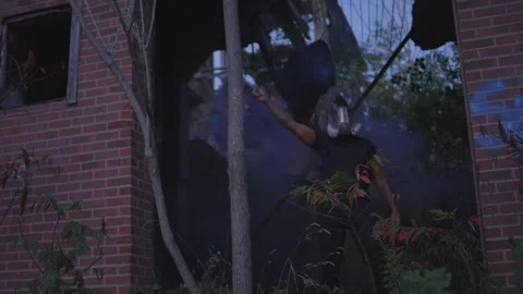 A black man waving a smoke grenade and wearing a gas mask in an abandoned Stock Footage 255565272