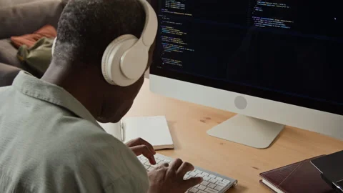 Black Man Wearing Headphones Programming Software on Computer Video stock 347653970