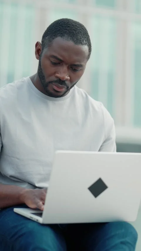 Black man working with laptop in park area, professional programmer or hacker Stock Footage 279807475