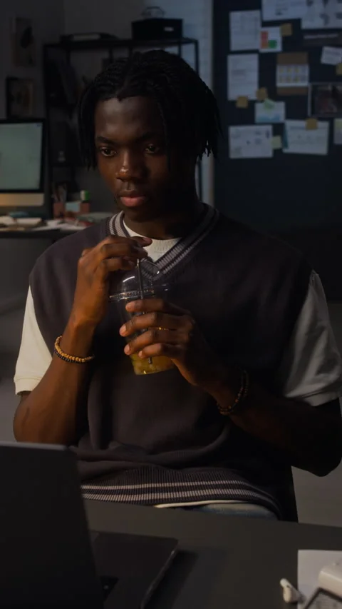 Black Man Working Late on Laptop in Office Drinking Beverage Stock Footage 338416148
