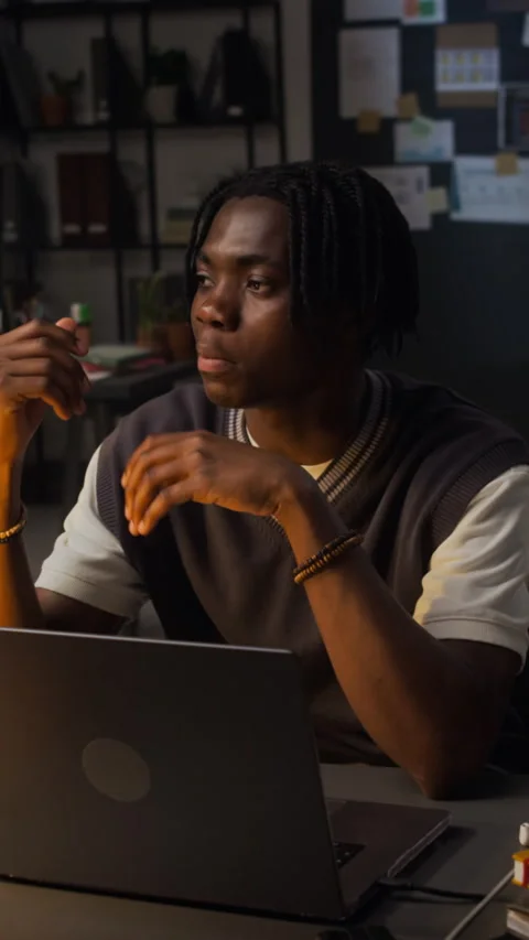 Black Man Working Late in Office Discussing Project on Laptop Stock Footage 338419568