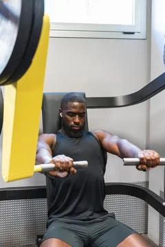 Black man working out hard on a gym machine Foto stock