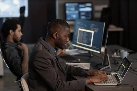 Black man writing code and typing at laptop keyboard Foto stock