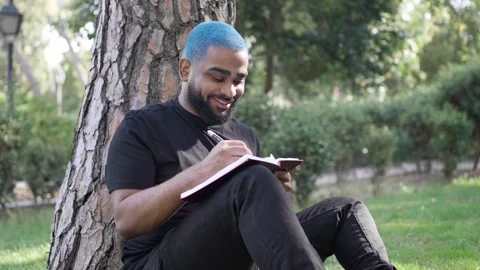 Black man writing notebook in park for thinking and relax for leisure Stock Footage 287487934