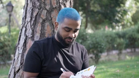 Black man writing in park thinking and relax for leisure in nature 스톡 동영상 287487776